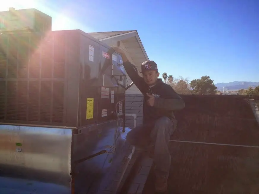 HVAC technician performing HVAC Inspection on a rooftop unit in Poulsbo